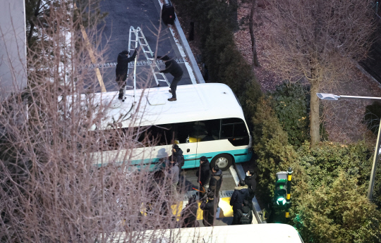 고위공직자범죄수사처(공수처)와 경찰이 윤석열 대통령에 대한 2차 체포영장 집행에 나선 15일 서울 용산구 한남동 대통령 관저 입구에서 경찰이 차벽을 넘기 위해 사다리를 설치하고 있다.<연합뉴스 사진>